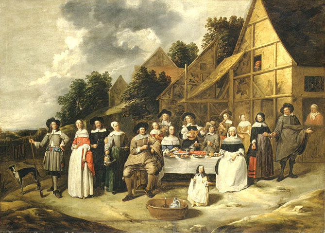 Voor een huis zit en staat een gezelschap rondom een rijk gedekte tafel.