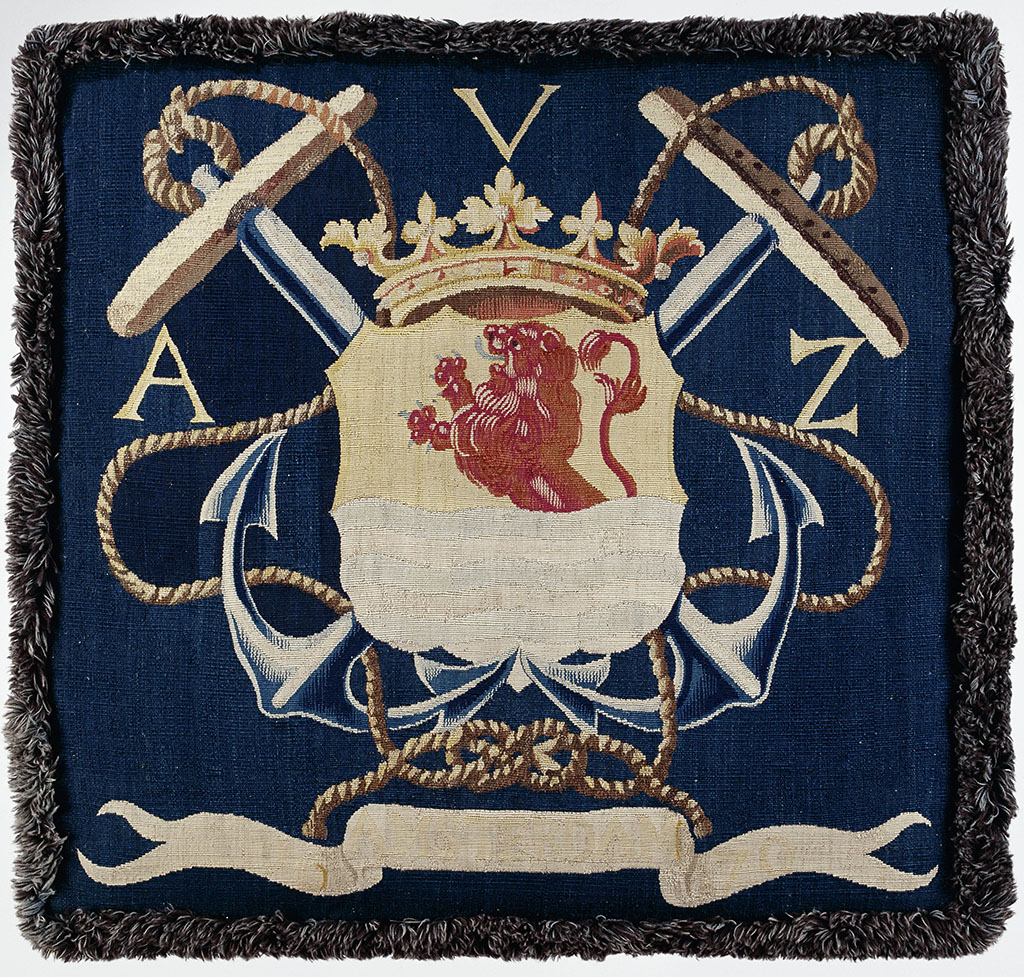 Kussenovertrek van tapisserieweefsel. Tegen een donkerblauwe achtergrond is het gekroonde wapen van Zeeland aangebracht, de leeuw in rood, het water in blauw. In de beide bovenhoeken een anker, voorts touwen. Boven de letters A.V.Z. en onder AMSTERDAM 1670.
