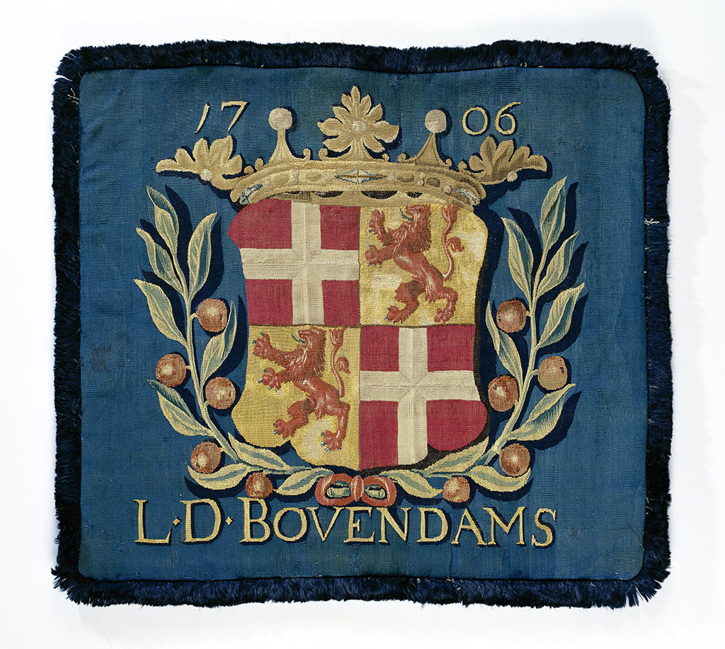 Magistratenkussen van tapijtweefsel met het gekroonde wapen van Utrecht en de inscriptie "L.D. Bovendams" Lekdijk Bovendams en het jaartal 1706.