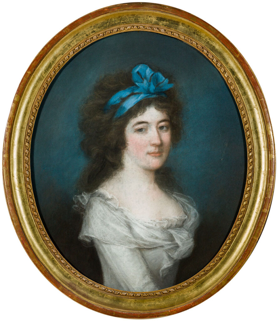 Ovaal busteportret van een vrouw met een grote bos donker krullend haar met daarin een blauwe strik. Ze zit naar rechts rekeerd en draagt een witte jurk.