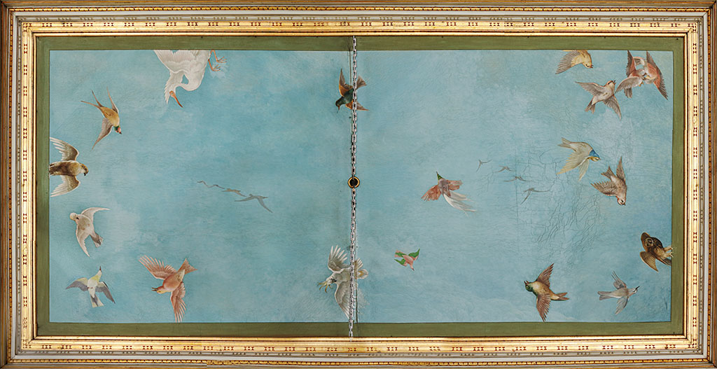 In een gouden kader zien we de lucht en daarin vliegen verschillende vogels.