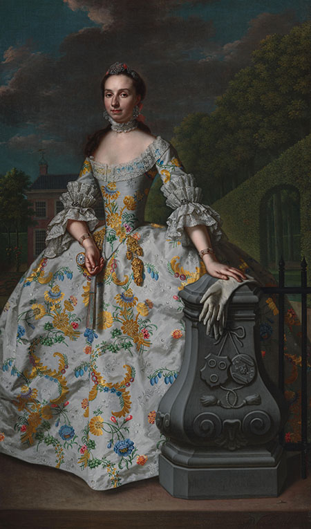 Portret van Charlotte Beatrix Strick van Linschoten (geb. 1732). Tweede echtgenote van Gerard Cornelis van Riebeeck, vermoedelijk staande voor haar buitenhuis Eemwijck te Voorburg. Staande, ten voeten uit, een waaier in de rechterhand, de linkerhand rustend op handschoenen liggend op een balustrade versierd met de familiewapens van haar en haar echtgenoot. Strick van Linschoten liet zich portretteren in een japon met goudgele en bontgekleurde bloemen. Ze staat voor een buitenplaats, waarschijnlijk Eemwijck, gelegen tegenover Essesteijn, waar haar man voor poseert. Bij zijn dood erfde ze beide huizen. Daarbij lietze een nieuwe boerderij bouwen, met haar initialen in de geveltop. Op dit portret laten de familiewapens op de balustrade zien wie de opdrachtgevers zijn.