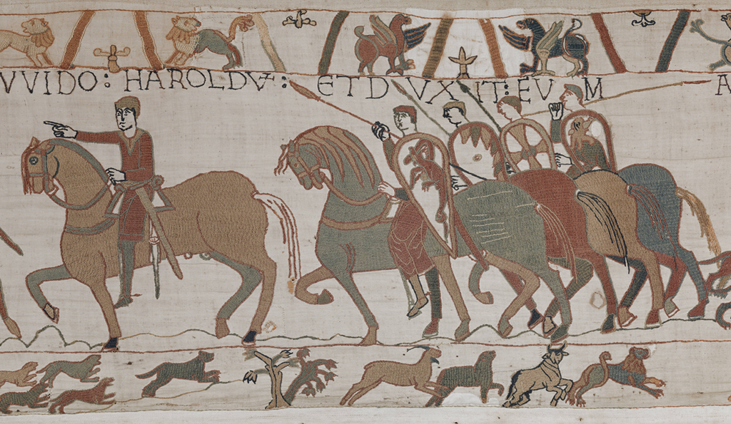 Een man rijdt op zijn paard naar links, hij wijst met de wijzer van zijn rechterhand vooruit. Achter hem drie ruiters te paard met in hun rechterhand een speer en in hun linkerhand een wapenschild. Elk schild heeft een ander motief. Boven en onder versieringen van (fabel-)dieren.