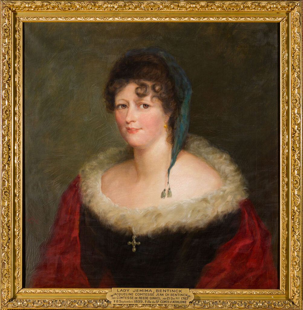 Een vrouw zit naar rechts, ze heeft donkere, bruine ogen en donkere krullen. Ze draagt een zwarte japon met witte veren langs decollete, roze-rode draperie, blauw-groen mutsje met afhangende punt met tweekwastjes, kruisje van parels middenvoor.