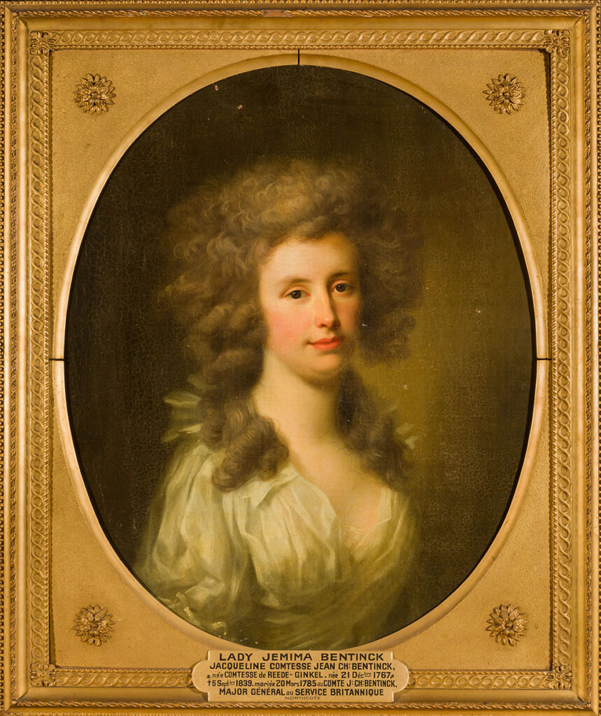 Halflengte portret van een jonge vrouw naar rechts gekeerd. Ze heeft een grote bos krullen en lange lokken liggen in haar nek. Ze heeft donkere ogen, blossen op haar wangen en frisrode lippen. Ze draagt een eenvoudige witte jurk met veel plooien en een diep decolleté.