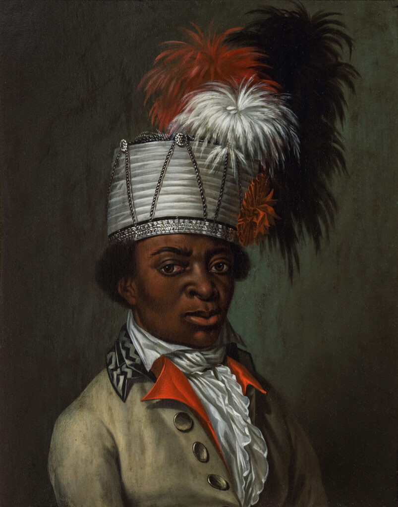 Een portret van een donkere man waarvan wordt gedacht dat het een bediende geweest zou zijn. Het werk is olieverf op paneel en heeft een eenvoudige, zwartgelakte, houten lijst met een vergulde binnenrand. De man is tot de borst afgebeeld in een 3/4 aanzicht tegen een egale, donkere achtergrond. Hij heeft een zogenaamde Redingote aan, in een beige stof met een versierde kraag, boven een rood gilet en een witte blouse. De man heeft een een randloze, cilindervormige hoed op zijn hoofd van wit geplooide stof, afgezet met zilverbrokaat. Op de zijkant van de hoed een rode stoffen rozet. Boven de hoed, drie pluimveren in wit, rood en blauw/zwart.
