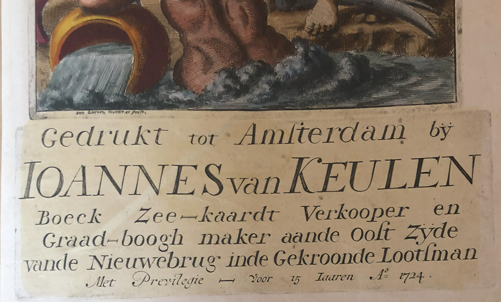 Deel van het titelblad van een atlas. We zien nog net de onderkant van een afbeelding (water en een voet). Daaronder staat "Gedrukt tot Amsterdam by IOANNES van KEULEN, Boeck Zee-kaardt Verkooper en Graad-boogh maker aander Oost zyde vande Nieuwebrug inde Gekroonde Lootsman. Met Previlegie Voor 15 Iaaren Ao 1724"
