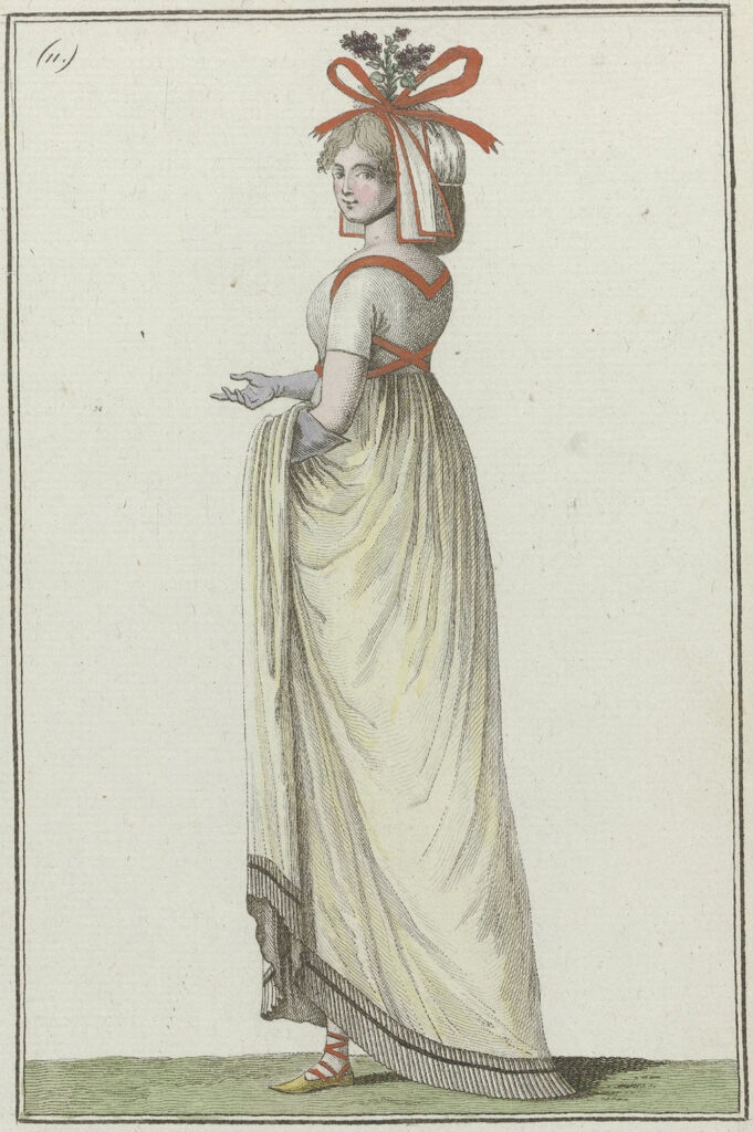 'Bonnet à la jardinière': grote muts versierd met linten en een takje van seringenbloesem. Japon met korte mouwen en 'Ceinture à la Victime', bij de zoom afgezet met smalle geplooide stroken (falbalas). Lange handschoenen, kousen, schoenen met gekruiste linten en puntige neuzen.