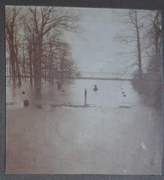 Uitzicht vanuit het kasteel naar het zuiden. De hele tuin staat onder water, de bomen en een paar buxussen steken nog boven het water uit. 