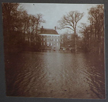 Het kasteel van een afstand. Wat normaal grasveld is, is nu één grote watervlakte