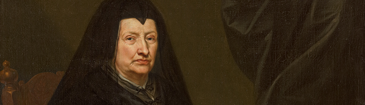 Een strengkijkende, oude vrouw met een zwarte muts en sluier tegen een donkere achtergrond.