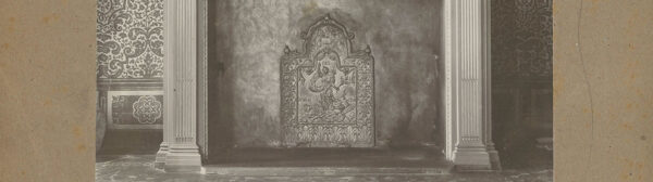 een oude zwartwitfoto van een haardplaat in een schouw