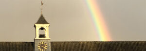 Dak van de stallen met klok en regenboog