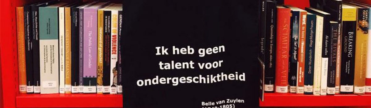 Een tas met de tekst "Ik heb geen talent voor ondergeschiktheid" hangt voor een boekenkast