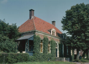 Een bakstenen huis van één verdieping hoog en bedekt met rode pannen. De voordeur zit in het midden met twee hoge ramen aan iedere kant. Het dak heeft twee koeken en twee schoorstenen. Het huis is begroeid met klimop en heeft een kleine veranda. Voor het huis staan grote bomen.