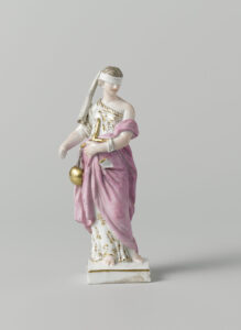 Figuur van beschilderd porselein. Op een vierkant goud gerand voetstuk staat een vrouw (Justitia) met een zwaard in haar rechterhand en een weegschaal over haar linkerarm. Zij is geblinddoekt. De figuur is gemerkt.