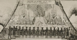 Aan een t-vormige tafel zitten allemaal dames en heren te dineren. Aan het hoofd van de tafel (voet van de T) zitten Willem en Mary. Links zitten mannen, rechts vrouwen. Aan de kop van de T zitten allemaal mannen en op de resterende plekken vrouwen. De tafel staat vol met hoog opgestapelde dissen. Voor komen bedienden met moikken binnen.
