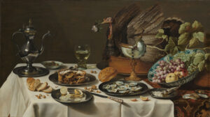 Op een tafel met een tafelkleed met patronen ligt ook een wittafelkleed. Achterop staat een grote pastei met daarop een opgezette kalkoen met een bloem in haar bek. Ervoor staat een kelk van een nautilus schelp een een keramieken schaal met druiven, appels en noten. op het tafelkleed liggen wat oesterschelpen. Voor de fruitschaal staat een klein tinnen bordje met een opgerold papiertje waar donkerbruin poeder (nootmuskaat?) uit komt. Op het bordje ligt al wit poeder. Links daarnaast een tinnen bord met oesters en daarnaast een tinnen bord met een geschilde en in schijfjes gesneden citroen, het mes met een versierd heft ligt er nog naast. Achter het bord met de citroen een tinnen bord met een aangebroken pastei, er ligt een lepel bovenop. Daarachter een tinnen of zilveren kan, een porseleinen schaaltje met olijven en een berkemeyer met witte wijn. op het witte tafelkleed liggen hazelnoten, walnoten een broodje, plakjes brood en een partje van een mandarijn.