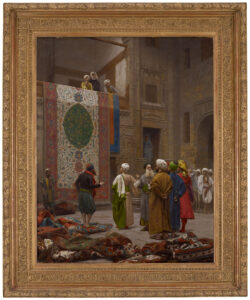 In een zware vergulde lijst een orientaals schilderij van een ruimte waar een groot tapijt van een balkon naar beneden hangt. eneden staan allemaal Arabische mannen te overleggen en op de grond liggen diverse tapijten opgepropt.